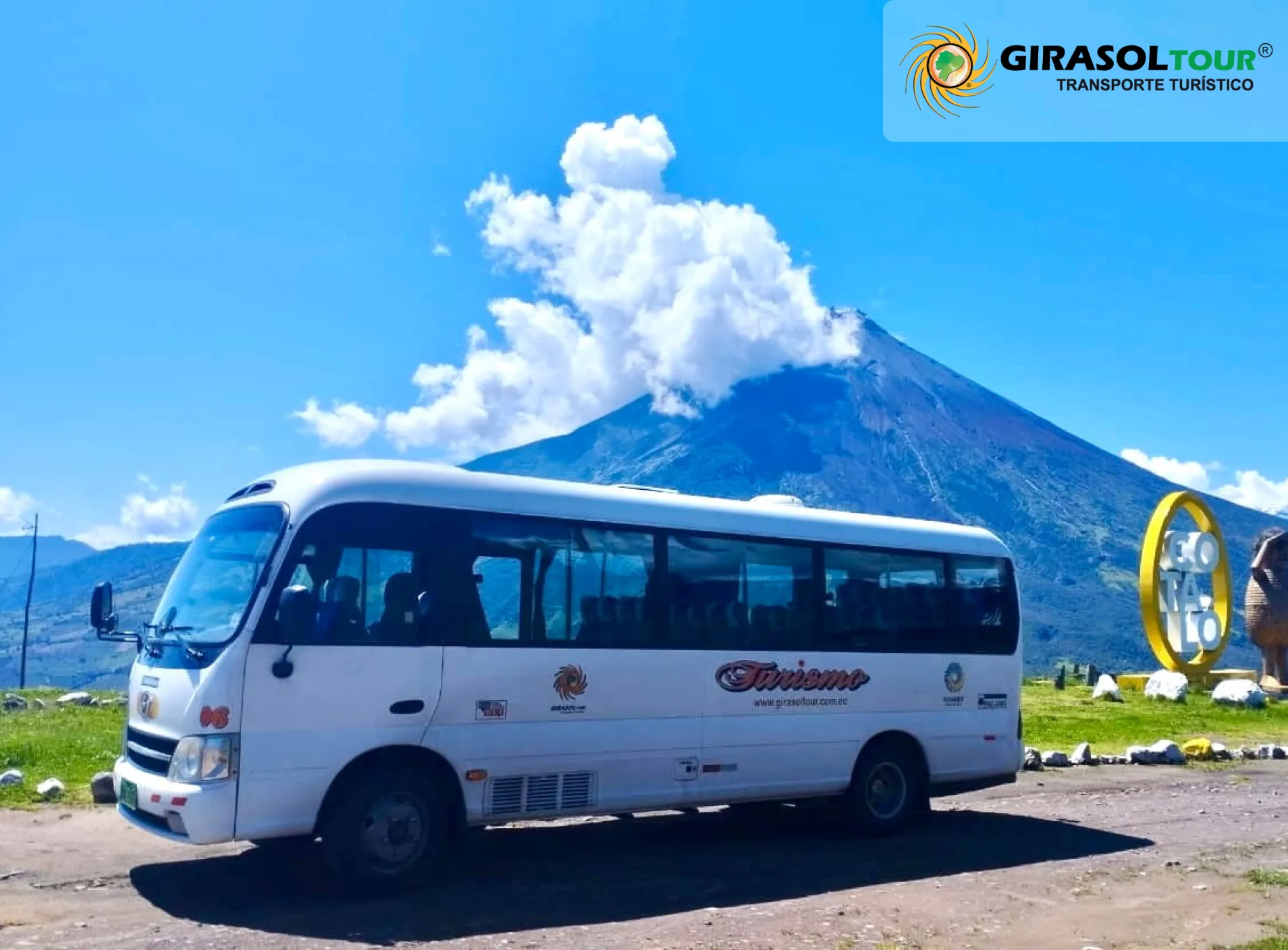 Minibus Mitsubishi blanco de Girasoltour estacionado con imponente volcán de fondo.